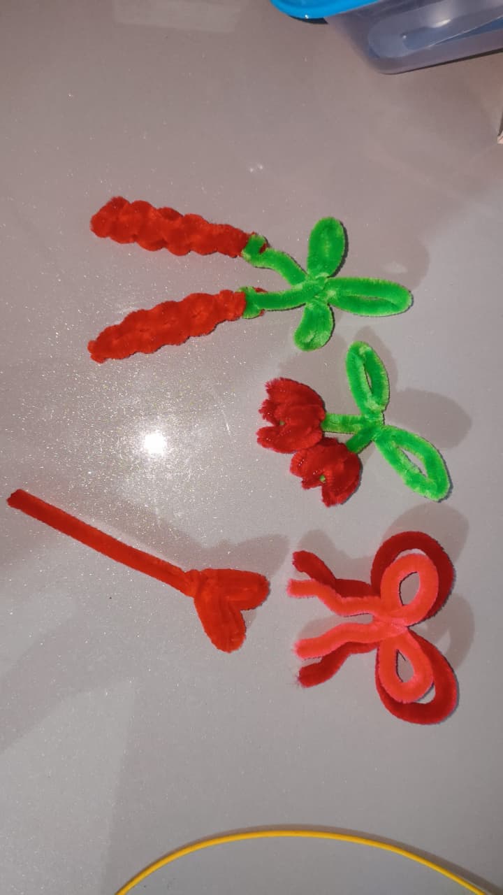 A chenille flower taking shape by hand at the worktable